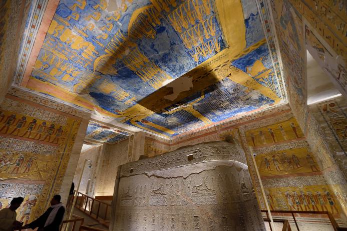 roof of a tomb decorated with human figures with blue and yellow as the dominant colours