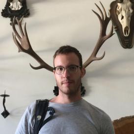 Richard Spiegel standing in front of an antler, so it looks like it if attached to his head