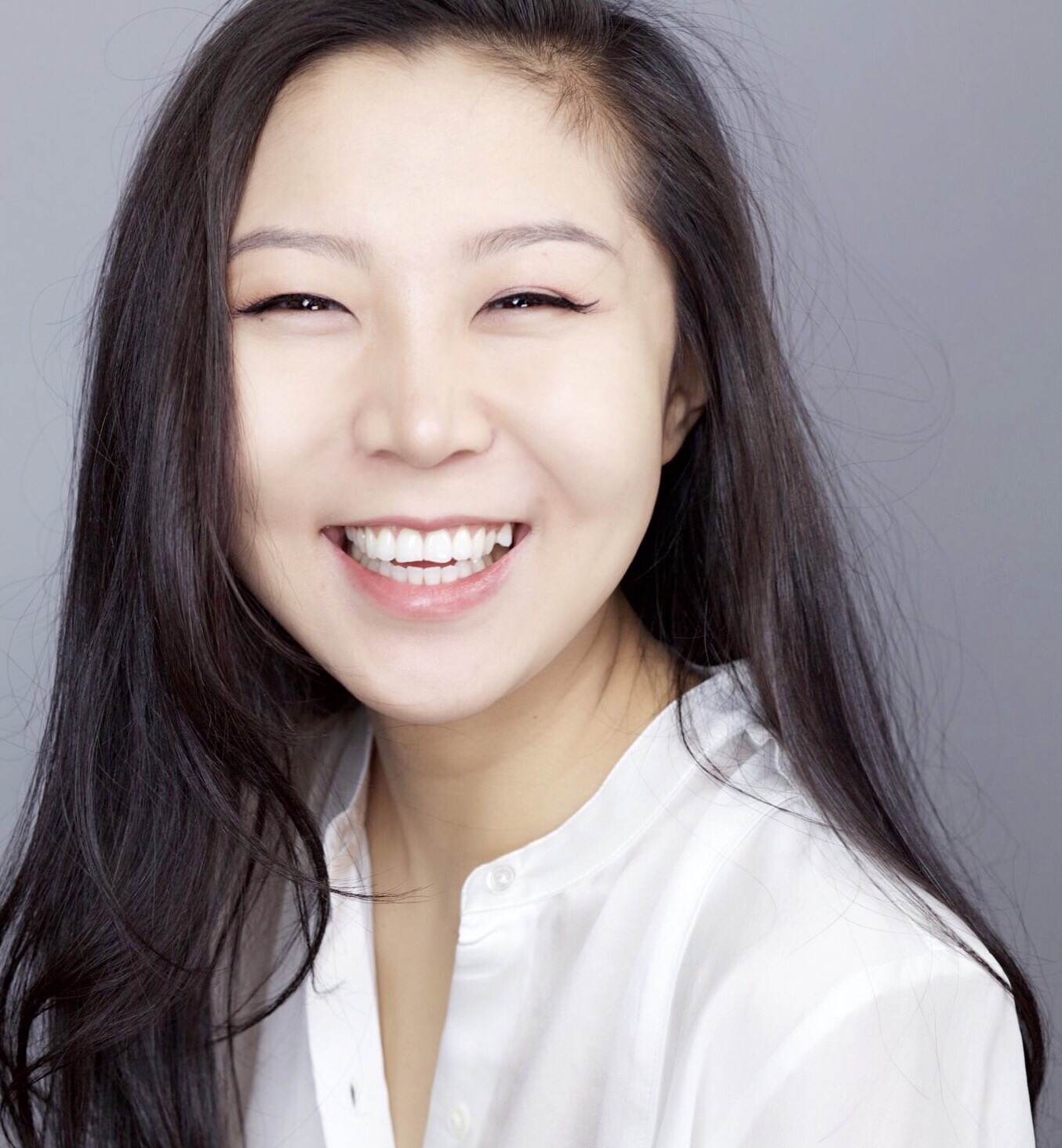 Yishu Mao (dark long hair, white shirt) smiling into the camera