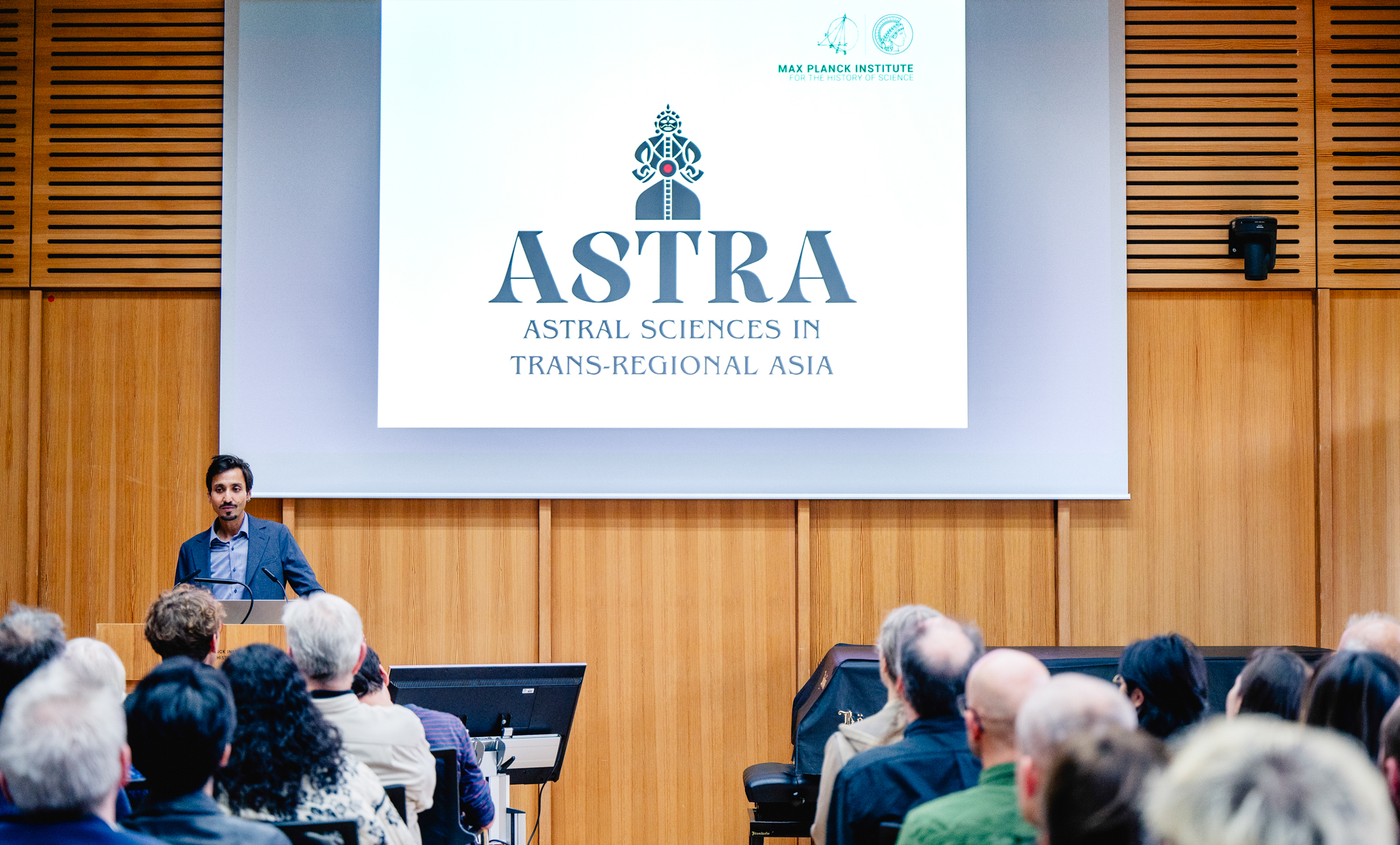 Research Group Leader Anuj Misra during his keynote speech at the MPIWG Research Group “Astral Sciences in Trans-Regional Asia” (ASTRA) launch event. Source: Sandra Prengel, 2024. ASTRA logo in the background by Anuj Misra, 2024.