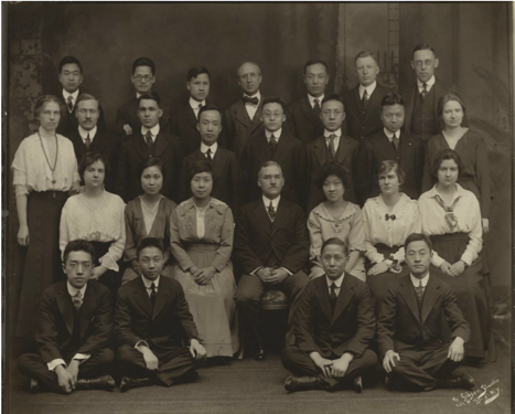 Portrait of Paul Monroe sitting surrounded by his students at Teachers College