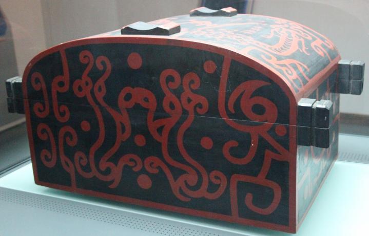 replica of a black lacquered wood suitcase with red asymmetrical patterns