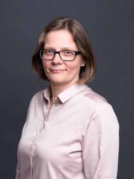 profile picture of Cathleen Paethe (light pink button-up shirt, glasses, half-length hair), dark background