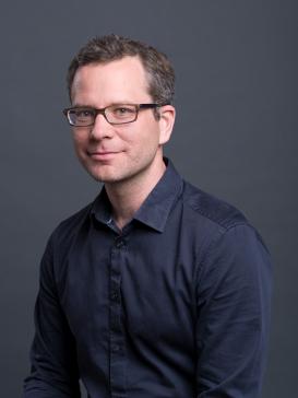 profile picture of Helge Wendt (glasses, dark shirt), dark background
