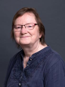 profile picture of Sonja Brentjes (blue shirt, wearing glasses), dark background