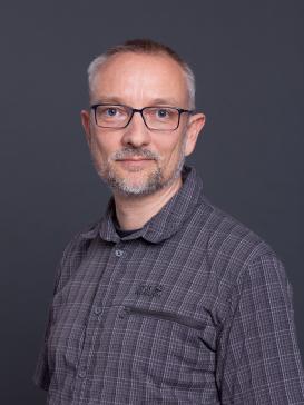 profile picture of Robert Casties (checkered button-up shirt, glasses), dark grey background