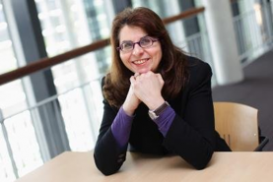 Lissa Louise Roberts sits at a table with her arms propped up