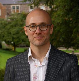 profile picture of Shane Butler, taken in a garden or a park