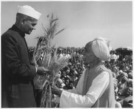 indian_farmer_passes_wheat_to_politician