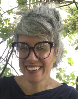 Profile of a woman wearing glasses and smiling