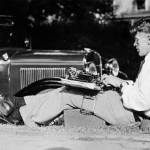 The sportsman and sports journalist Lauri "Tahko" Pihkala is writing on a typewriter in 1932. The typewriter is attached to the thighs with Knefix pliers, developed by Pihkala, so that the writer can write in any position needed.