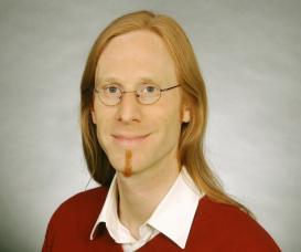 profile picture of Karsten Lichau (long hair, glasses, red sweater)