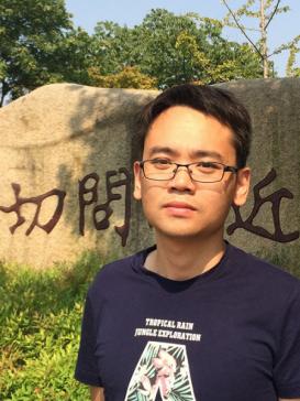 Xi Chen in front of a stone with an inscription