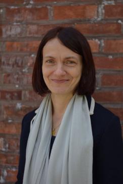 Catherine Stuer in front of a brick wall