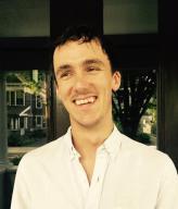 Henry Cowles wearing a white button-up shirt in front of a window
