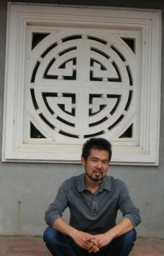 Masahiro Terada in front of an ornamental window