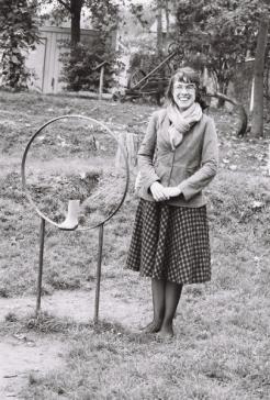 greyscale image of Brooke Penaloza Patzak standing on a meadow next to a ring with a rubber boot